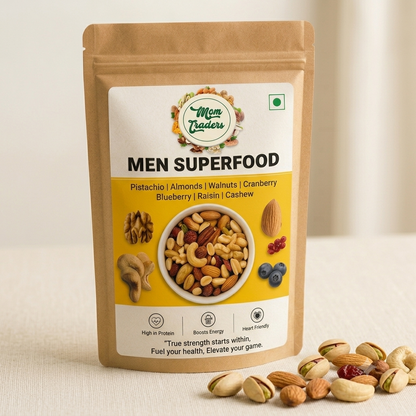 A stand-up pouch of Mom Trader's Men Superfood nuts and dried fruits, displayed on a light beige surface with scattered pistachios in the foreground.